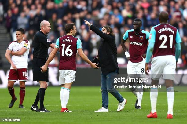 Mark Noble of West Ham United confronts a pitch Invader during the Premier League match between West Ham United and Burnley at London Stadium on...