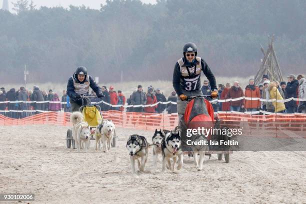 Andre Tegeler alias DJ Moguai and German actor Markus Knuefken run with sled dogs during the 'Baltic Lights' charity event on March 10, 2018 in...