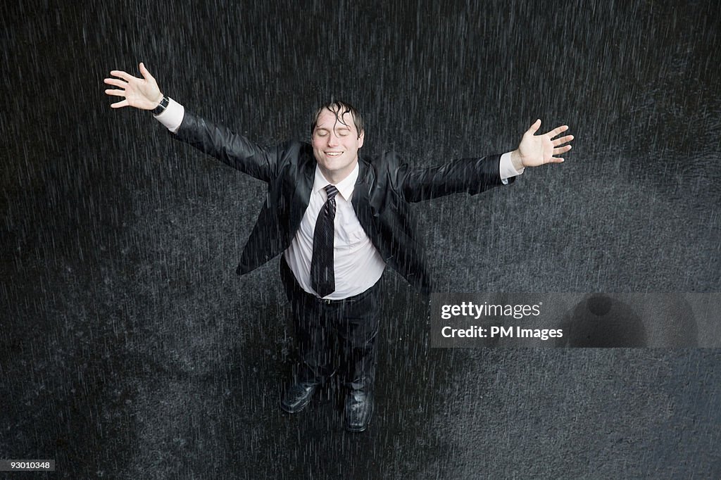 Businessman smiling in rain