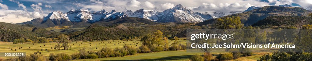 Panoramic view of Double RL Ranch shows Hay Bales under Mount Sneffels and San Juan Mountains in Autumn