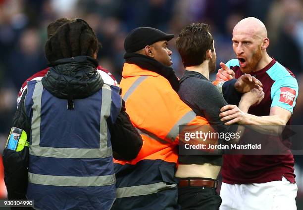 James Collins of West Ham United confronts a pitch invader during the Premier League match between West Ham United and Burnley at London Stadium on...