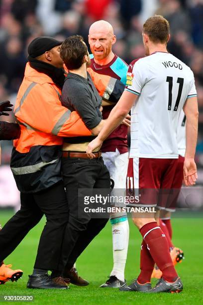 West Ham United's Welsh defender James Collins confronts a pitch invader during the English Premier League football match between West Ham United and...