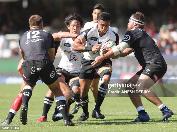 William Tupou of the Sunwolves is tackled by Andre Esterhuisen and John-Hubert Meyer of the Sharks during the Super XV Rugby Union match between the...