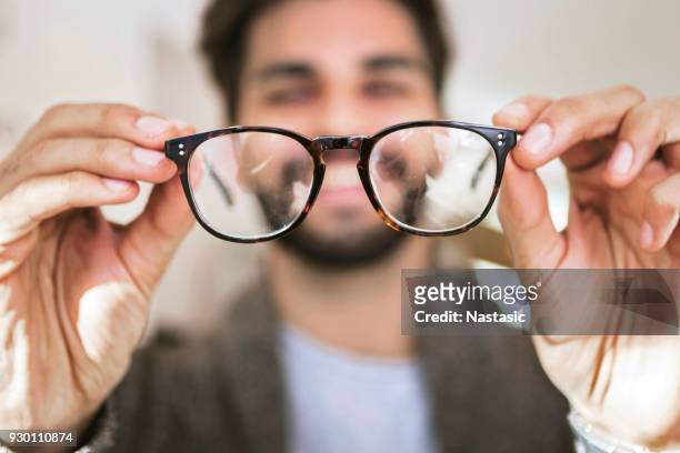 het kiezen van een bril in optische winkel man - hand glasses stockfoto's en -beelden
