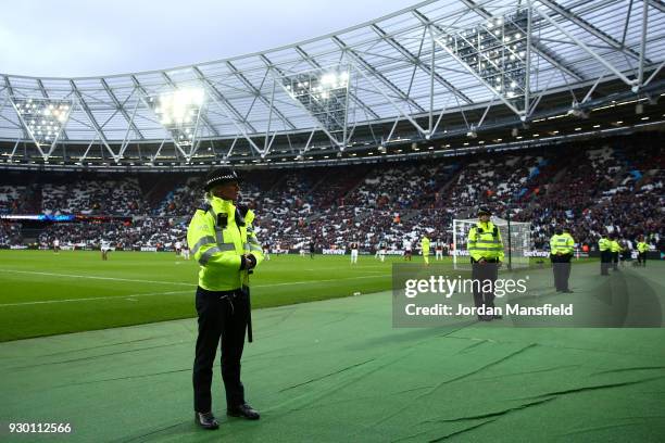 Police look on at the fans after the Premier League match between West Ham United and Burnley at London Stadium on March 10, 2018 in London, England.
