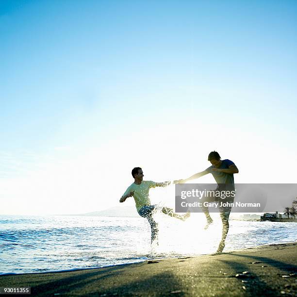 male couple enjoy time at the beach - gary bond stock pictures, royalty-free photos & images