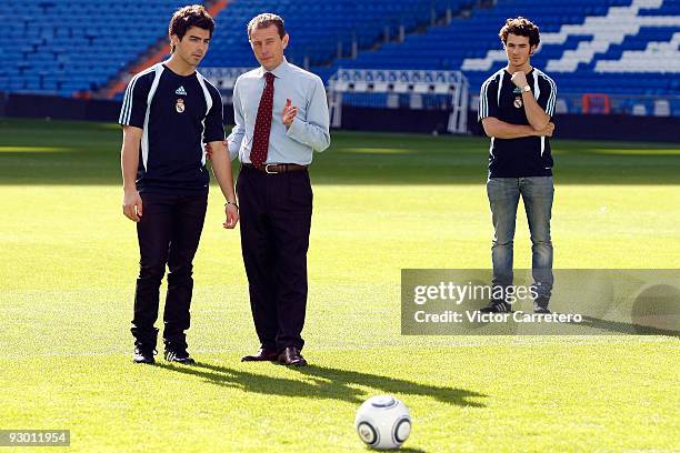 Emilio Butragueno talks with Joe Jonas as Kevin Jonas of the Jonas Brothers looks on during the band's visit as guests of Real Madrid as they visit...