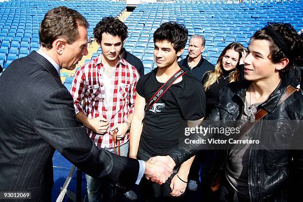 Emilio Butragueno greets Kevin Jonas, Joe Jonas and Nick Jonas of the Jonas Brothers during the band's visit as guests of Real Madrid as they visit...