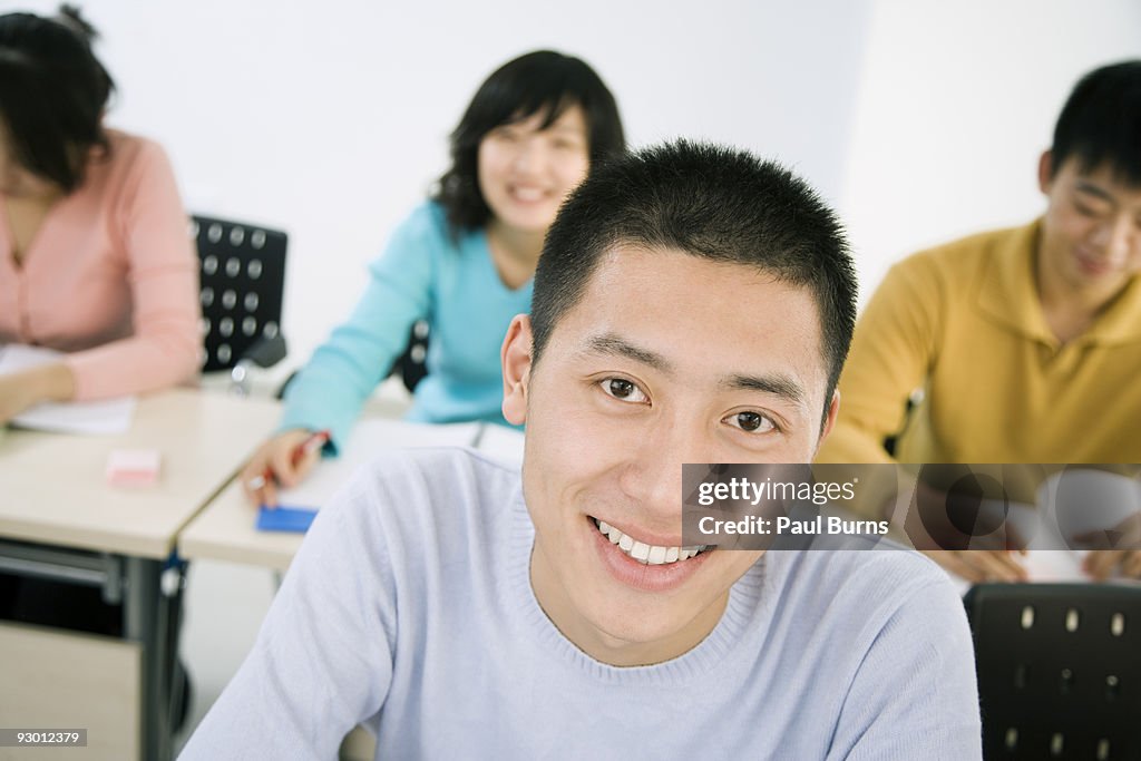Boy smiling with classmates in the back