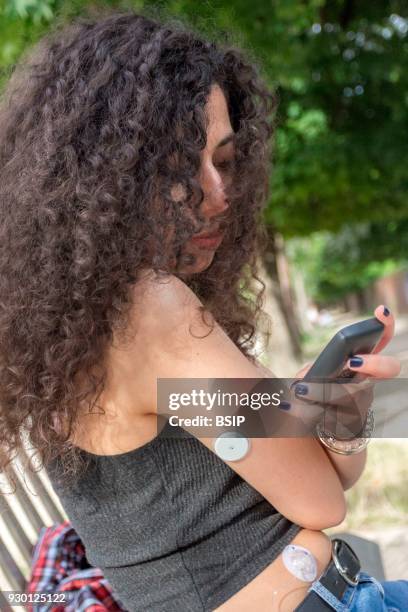 Diabetic teen equipped with glucose sensor and Freestyle Libre scanner which can just be flashed at the sensor on the back of arm to instantly...