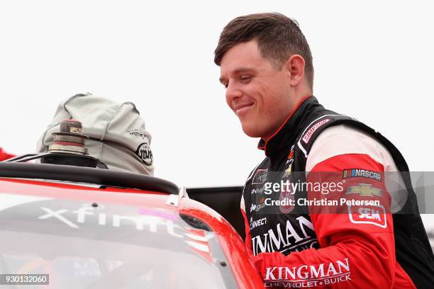 Spencer Gallagher, driver of the Kingman Chevrolet Chevrolet, climbs into his car during qualifying for the NASCAR Xfinity Series DC Solar 200 at ISM...
