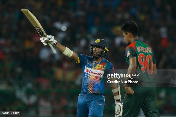 Sri Lankan cricketer Kusal Mendis raises his bat after scoring 50 runs during the 3rd T20 cricket match of NIDAHAS Trophy between Sri Lanka and...