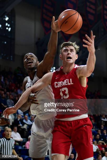 Chris Lewis of the Harvard Crimson and Stone Gettings of the Cornell Big Red vie for the ball during the first half of a semifinal round matchup in...