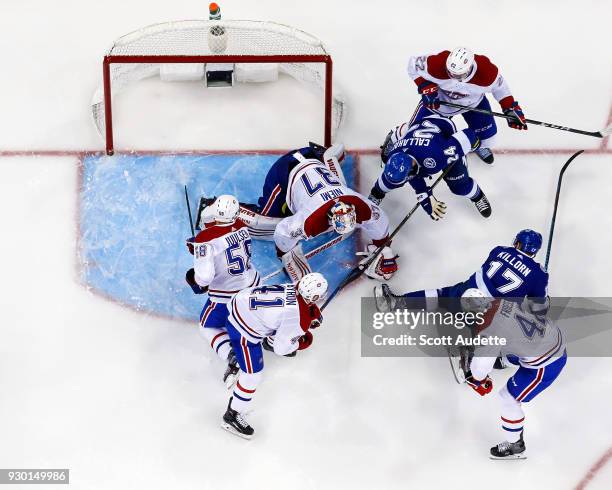 Ryan Callahan and Alex Killorn of the Tampa Bay Lightning battle for the puck against goalie Antti Niemi, Noah Juulsen, Paul Byron, Karl Alzner, and...