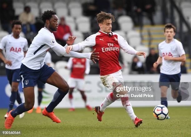 Vlad Dragomir of Arsenal passes the ball under pressure from Christian Maghoma of Tottenham during the match between Arsenal and Tottenham Hotspur at...