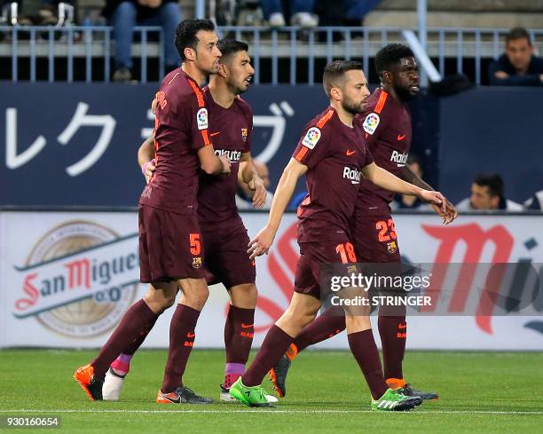 Barcelona's Uruguayan forward Luis Suarez celebrates a goal with teammates during the Spanish league football match between Malaga CF and FC...