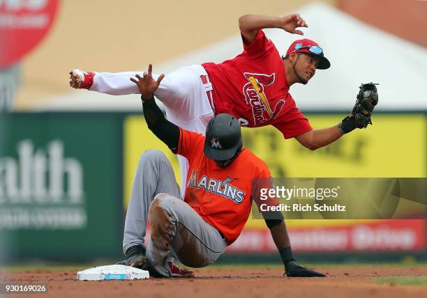 Lewis Brinson of the Miami Marlins upends second baseman Breyvic Valera of the St. Louis Cardinals after being tagged out attempting to steal second...