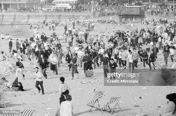 Mods v Rockers. Picture shows the scene at Margate, North East Kent in May 1964. Mods run across the beach, disturbing the holiday makers as they go....