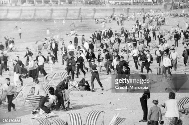 Mods v Rockers. Picture shows the scene at Margate, North East Kent in May 1964. Mods run across the beach, disturbing the holiday makers as they go....
