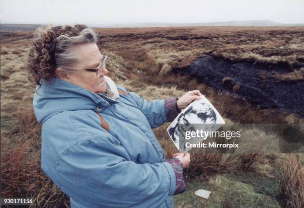 Mrs Winifred Johnson, mother of missing boy Keith Bennett, pictured on Saddleworth Moor, with a photograph of her son, 25th January 1995. The Moors...