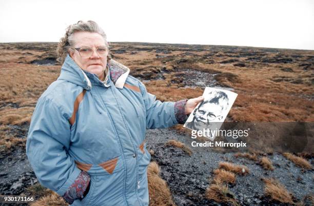 Mrs Winifred Johnson, mother of missing boy Keith Bennett, pictured on Saddleworth Moor, with a photograph of her son, 25th January 1995. The Moors...