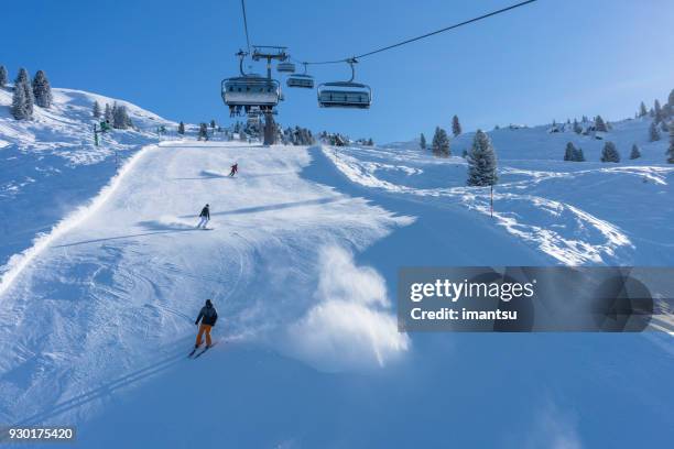 skiers and ski lift on the zillertal arena track - zillertal stock pictures, royalty-free photos & images