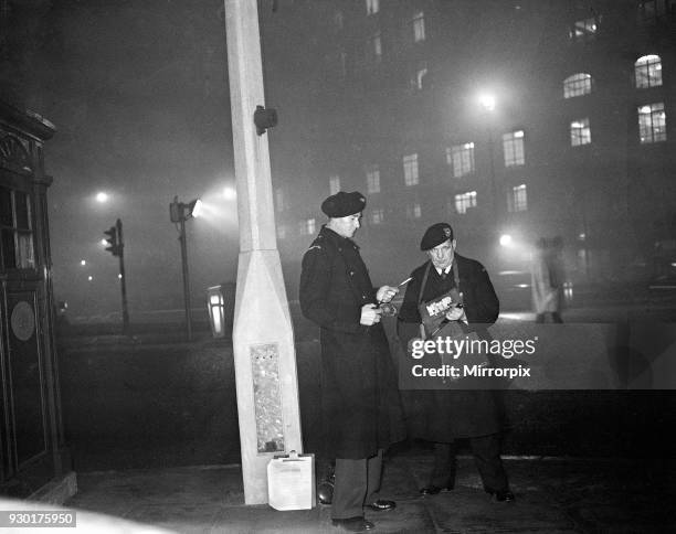 Smog wardens holding flares in thick fog in Central London, 5th January 1956.