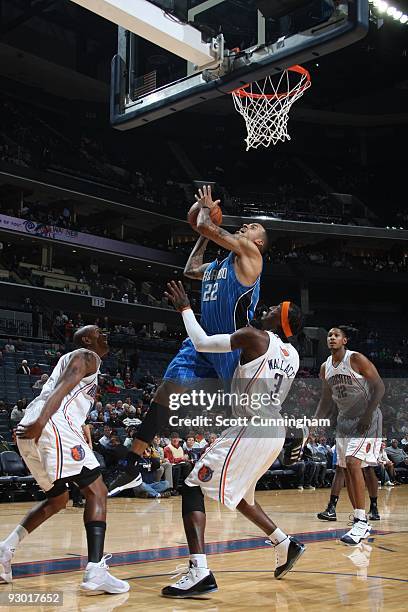 Matt Barnes of the Orlando Magic shoots against Raja Bell and Gerald Wallace of the Charlotte Bobcats during the game on November 10, 2009 at the...
