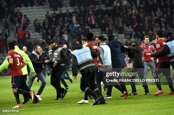 Lille' supporters invade the pitch at the end of the French L1 football match between Lille and Montpellier on March 10, 2018 at the Pierre Mauroy...