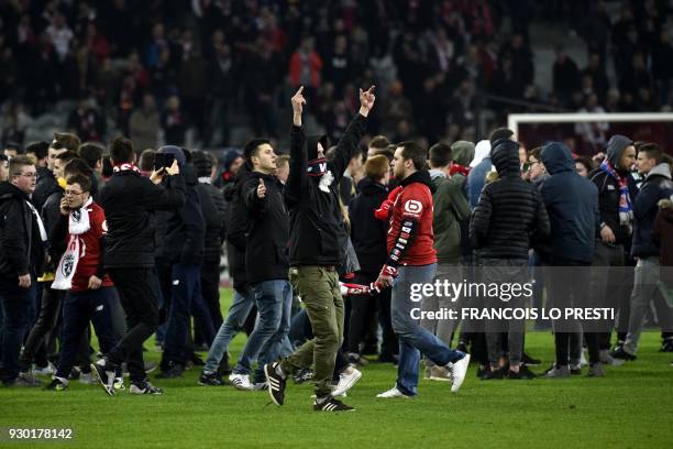 Lille's supporters invade the pitch at the end of the French L1 football match between Lille and Montpellier on March 10 at the Pierre Mauroy Stadium...