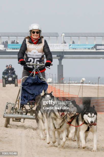 German presenter Inka Schneider runs with sled dogs during the 'Baltic Lights' charity event on March 10, 2018 in Heringsdorf, Germany. The annual...