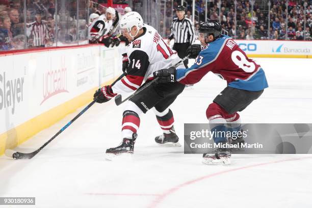 Richard Panik of the Arizona Coyotes controls the puck in front of Matt Nieto of the Colorado Avalanche at the Pepsi Center on March 10, 2018 in...