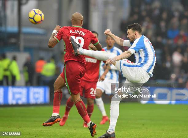 Scott Malone of Huddersfield Town clears the ball past Andre Ayew of Swansea City during the Premier League match between Huddersfield Town and...