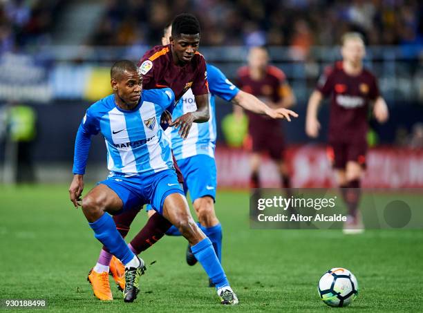 Ousmane Dembele of FC Barcelona duels for the ball with Diego Rolan of Malaga during the La Liga match between Malaga and Barcelona at Estadio La...