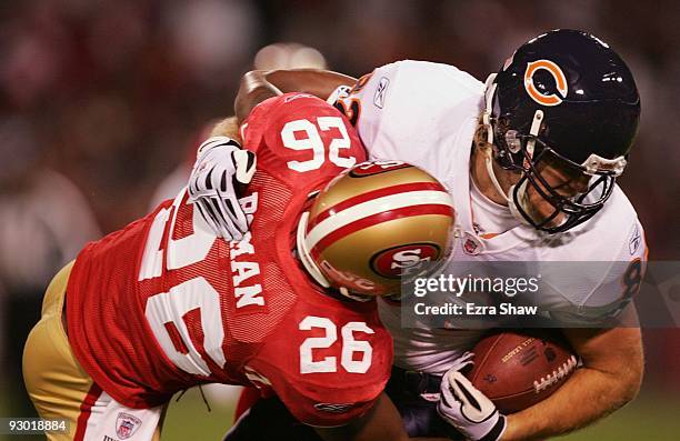 Tight end Greg Olsen of the Chicago Bears is tackled by Mark Roman of the San Francisco 49ers in the first quarter at Candlestick Park on November...