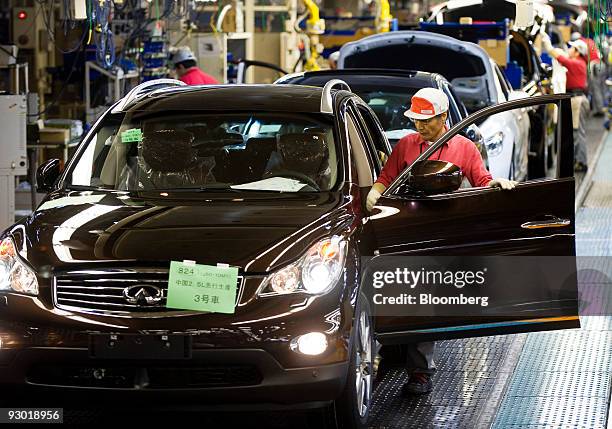 Nissan Motor Co.'s Infiniti brand vehicles bound for China, are given a final check after passing through the assembly line at the company's Tochigi...