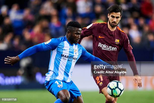 Andre Gomes of FC Barcelona duels for the ball with Isaac Success of Malaga during the La Liga match between Malaga and Barcelona at Estadio La...