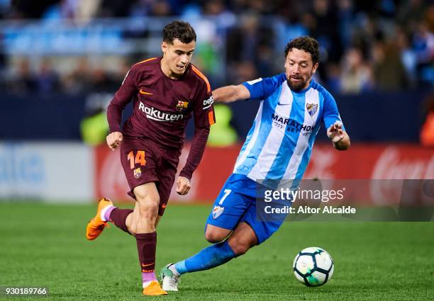 Philippe Coutinho of FC Barcelona duels for the ball with Manuel Rolando Iturra of Malaga during the La Liga match between Malaga and Barcelona at...