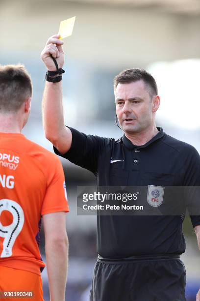 Referee Eddie Ilderton shows a yellow card to Chris Long of Northampton Town during the Sky Bet League One match between Bristol Rovers and...