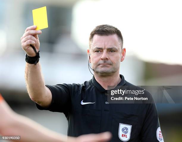 Referee Eddie Ilderton shows a yellow card to Chris Long of Northampton Town during the Sky Bet League One match between Bristol Rovers and...