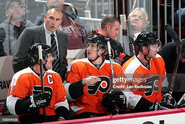 Mike Richards, James van Riemsdyk, and Jeff Carter of the Philadelphia Flyers talk with assistant coach Craig Berube during a stoppage in play...