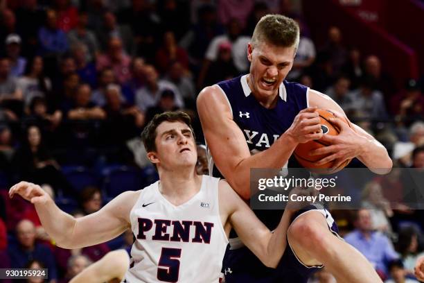 Blake Reynolds of the Yale Bulldogs grabs a rebound against Jackson Donahue of the Pennsylvania Quakers during the second half of a semifinal round...