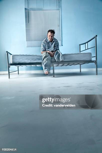 depressed, one-legged man in his lonely room - vandervelden stock pictures, royalty-free photos & images