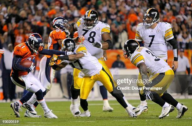 Andre Goodman of the Denver Broncos is stopped by Mike Wallace of the Pittsburgh Steelers after he intercepted a pass by quarterback Ben...