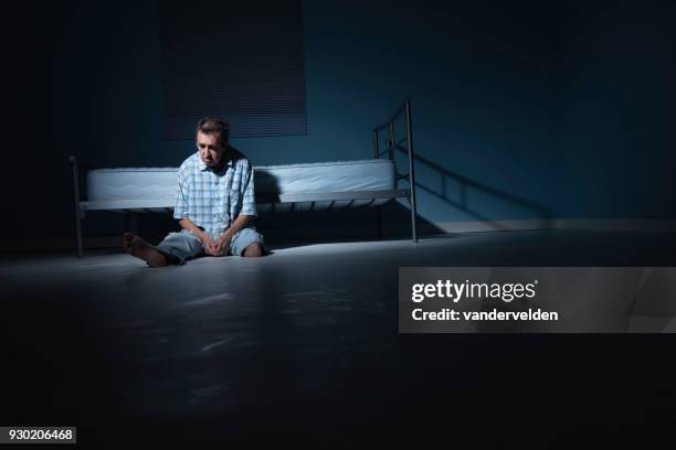 depressed, one-legged man in his stark room - vandervelden stock pictures, royalty-free photos & images