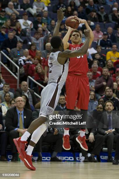 Kellan Grady of the Davidson Wildcats shoots the ball against Matt Mobley of the St. Bonaventure Bonnies in the Semifinals of the Atlantic 10...