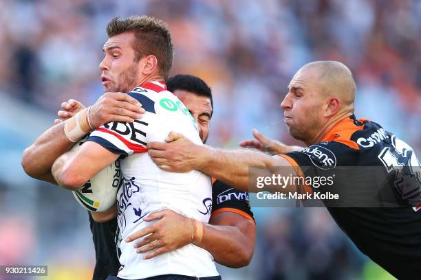 Mitch Cornish of the Roosters is tackled during the round one NRL match between the Wests Tigers and the Sydney Roosters at ANZ Stadium on March 10,...