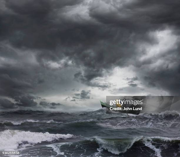 sailor rowing a small boat through an ocean storm - ruffled stock-fotos und bilder