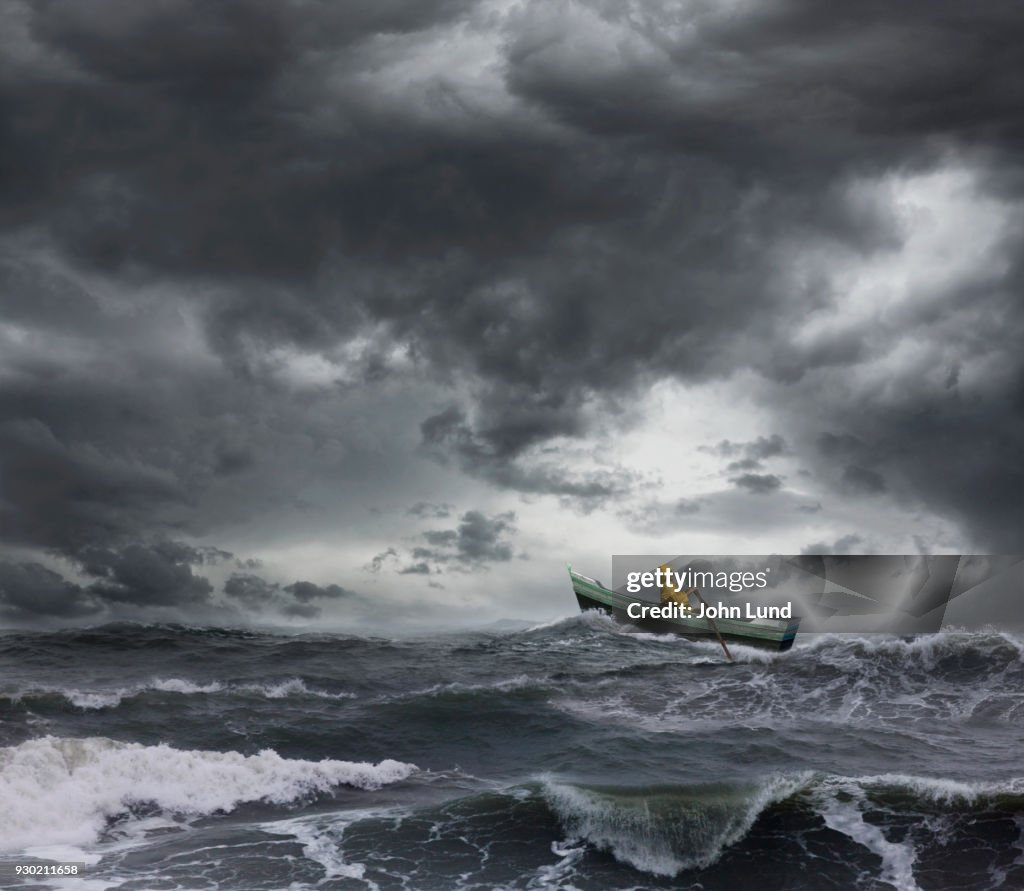 Sailor Rowing A Small Boat Through An Ocean Storm