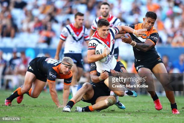 Victor Radley of the Roosters is tackled during the round one NRL match between the Wests Tigers and the Sydney Roosters at ANZ Stadium on March 10,...